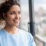A woman hopefully and happily looks toward her future in the home care industry.