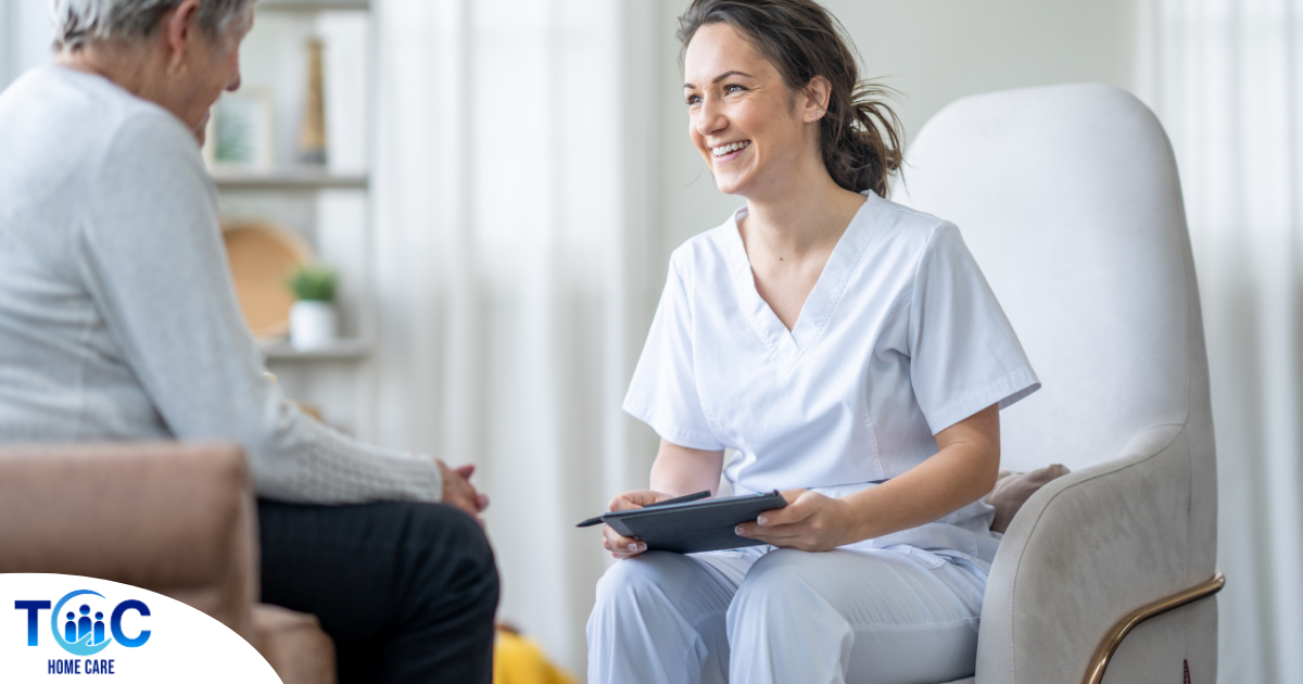 A woman smiles and enjoys her caregiving job as she writes notes down with a client.