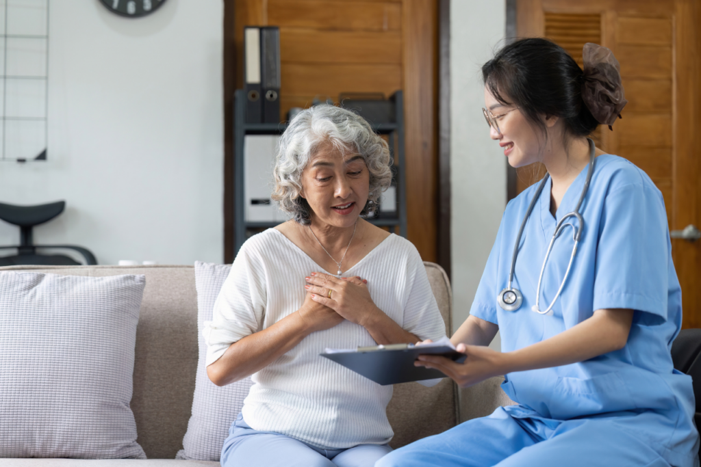 A care giver an a elderly patient sit together looking at medical records. Home Care in San Marino