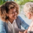 A caregiver warmly speaks with an older client, representing the quality communication that can come with bilingual care.