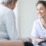A woman smiles while with a client representing the pros of the home care industry.