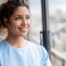 A woman smiles while looking ahead hopefully, showing the positive outlook that planning for a home care career can bring.