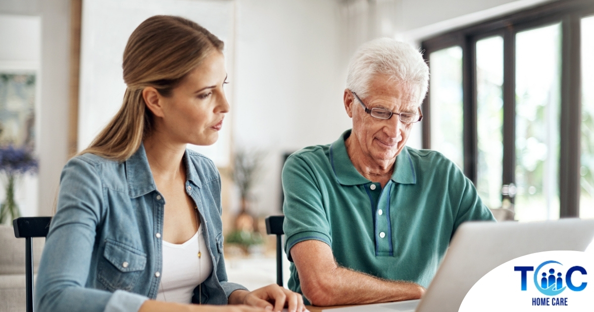 Adult daughter and senior father talking at a kitchen table while comparing home care vs assisted living